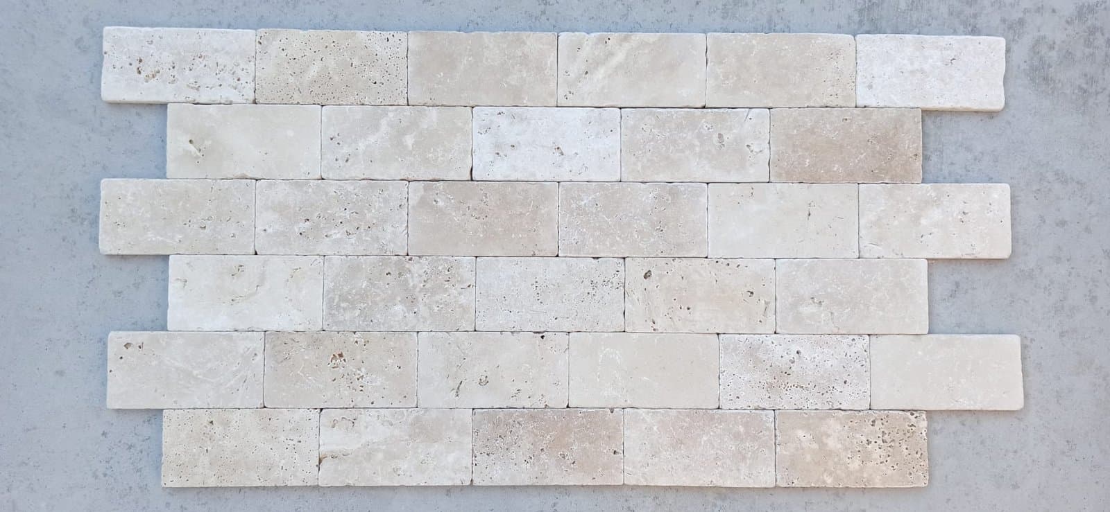 Brick tegels: lichte travertin bricks van 7,5 × 20,3 cm in halfsteensverband, getrommeld